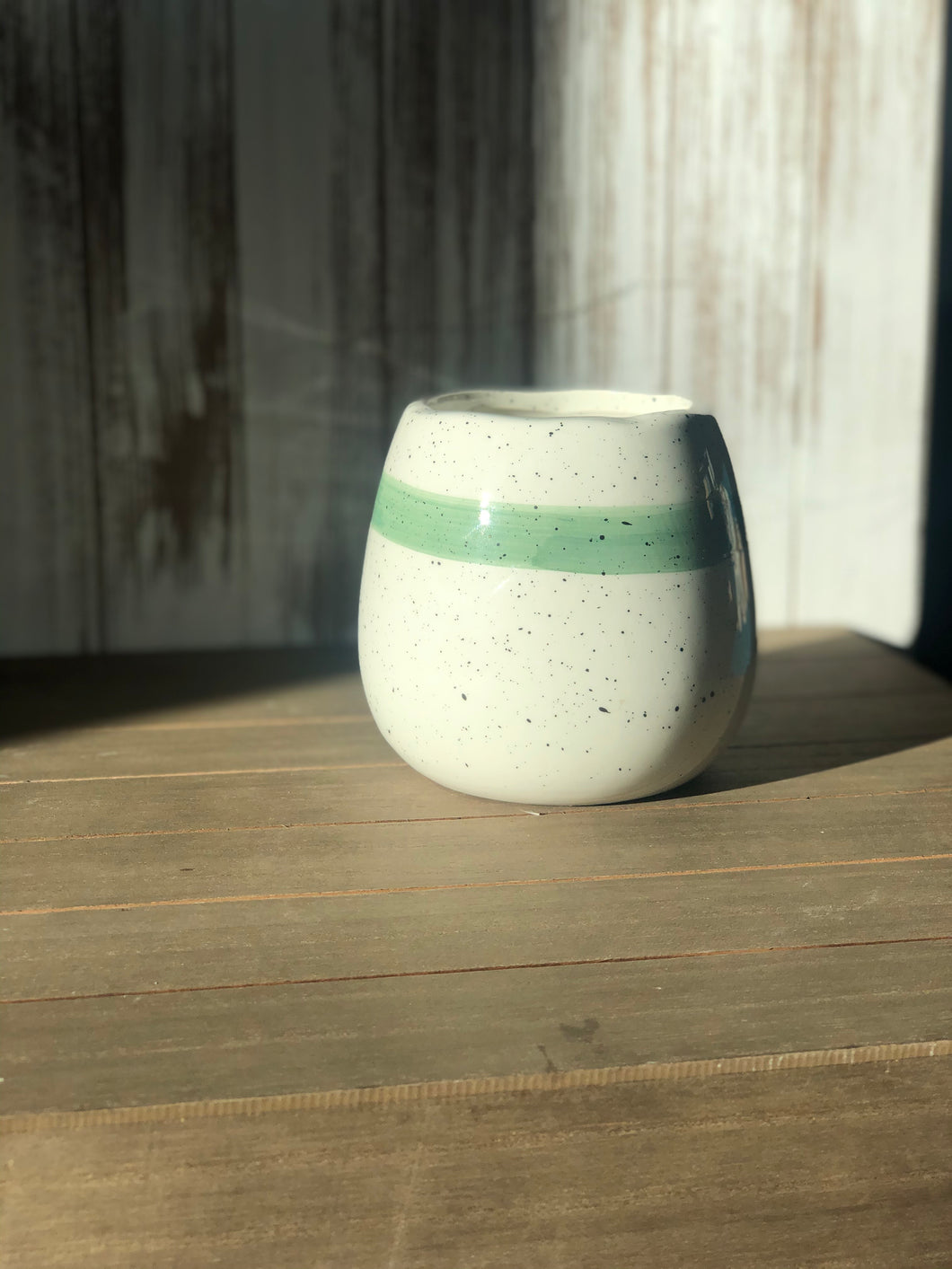 White speckled ceramic container with teal rim